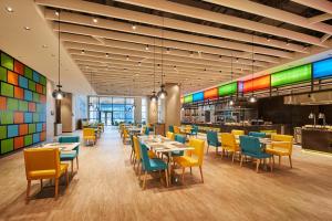 a dining room with tables and chairs and colorful walls at Aloft Shanghai Zhangjiang Haike in Shanghai