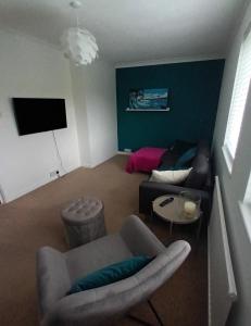a living room with a couch and a chair at Swansea Marina apartment in Swansea