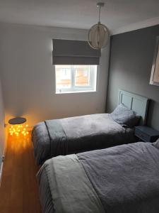 a bedroom with two beds and a window at Swansea Marina apartment in Swansea