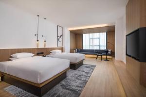 a hotel room with two beds and a flat screen tv at Fairfield by Marriott Xi'an North Station in Xi'an