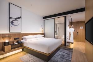 a bedroom with a large white bed and a mirror at Fairfield by Marriott Xi'an North Station in Xi'an