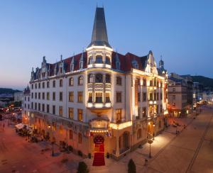 a large white building on a street at night at Grandhotel Ambassador Národní Dům in Karlovy Vary