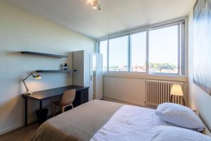 Schlafzimmer mit einem Bett, einem Schreibtisch und einem Fenster in der Unterkunft Le Carnot - A 5min à pied du centre d'Agen in Agen