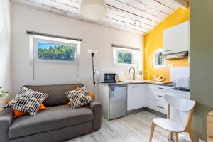 uma sala de estar com um sofá e uma cozinha em Gite l'Instant - Au cœur d'une oliveraie em Belgentier