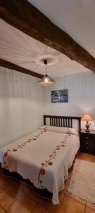 1 dormitorio con 1 cama con manta blanca en Casa Mariana en Lubián