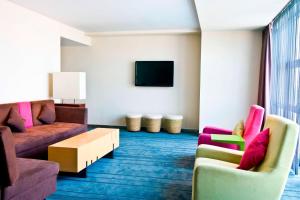 a living room with two couches and a tv at Aloft Beijing, Haidian in Beijing