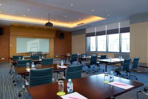 a conference room with tables and chairs and a projection screen at Aloft Beijing, Haidian in Beijing