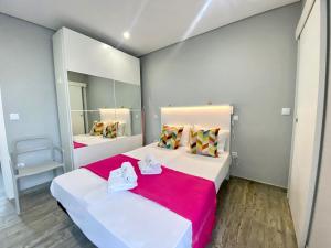 a bedroom with two beds and a mirror at Quarteira Stylish 2 by Homing in Quarteira