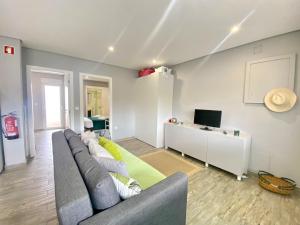 a living room with a couch and a television at Quarteira Stylish 2 by Homing in Quarteira