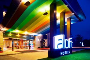 a brightly lit building with a sign in front of it at Aloft Dynamic Town in Longgang