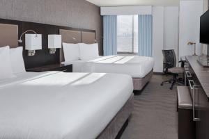a hotel room with two beds and a desk at Fairfield Inn & Suites by Marriott New York Staten Island in Staten Island