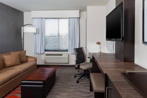 a living room with a couch and a television at Fairfield Inn & Suites by Marriott New York Staten Island in Staten Island