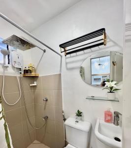 a bathroom with a shower and a toilet and a sink at Two-Bedroom Townhouse Camella Bacolod South in Bacolod