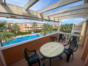een balkon met een tafel en stoelen en een zwembad bij Estrella Blanca VI, 2 dormitorios, by Bookindenia in Denia