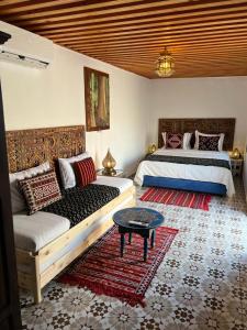 1 Schlafzimmer mit 2 Betten, einem Sofa und einem Tisch in der Unterkunft Dar Mounia in Rabat