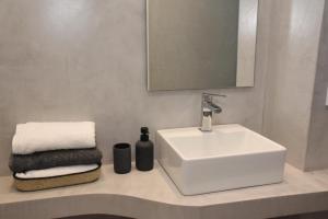 a bathroom with a sink and a mirror and towels at Athens Benaki 8 Suite in Athens