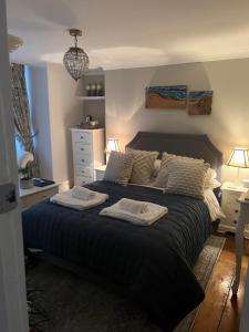 um quarto com uma cama grande com duas toalhas em The Captain's House em Looe