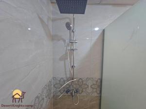 a shower with a shower head in a bathroom at Desert Knights camp in Wadi Rum