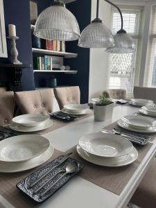 uma mesa de jantar com pratos brancos em The Captain's House em Looe