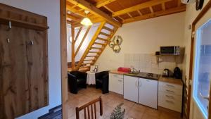 a kitchen and a living room with a staircase at Pikoló Vendéglő és Vendégház in Bakonybél