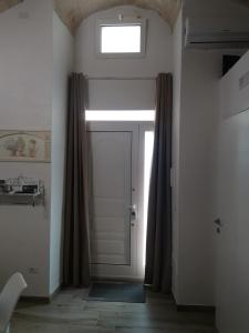 eine Tür in einem Zimmer mit Fenster in der Unterkunft SaLò Apartments in Manfredonia