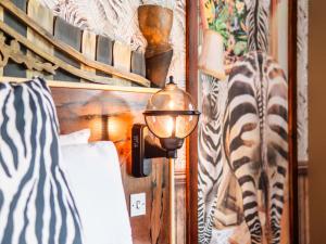 a room with a bed and a lamp on a wall at Chessington Hotel in Chessington