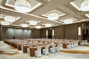 Four Points by Sheraton Langfang, Gu'an في Gu'an: غرفة كبيرة فيها صفوف من الكراسي والثريات