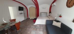 ein Hotelzimmer mit einem Bett, einem Tisch und einer Uhr in der Unterkunft Ninsòle in La Morra