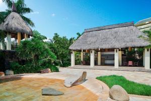 einen Pavillon mit einem Grasdach und einer Terrasse in der Unterkunft Sheraton Sanya Yalong Bay Resort in Sanya