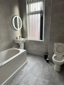 a bathroom with a tub and a toilet and a sink at Bex Stays 2 Bed Property in Leeds