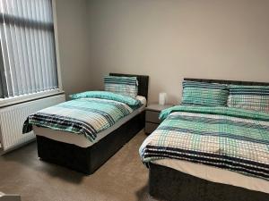 two beds sitting next to each other in a bedroom at Bex Stays 2 Bed Property in Leeds