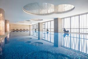 un rendimiento de una piscina en un edificio en Sheraton Changzhou Xinbei Hotel, en Changzhou