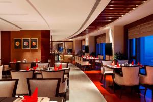 a restaurant with tables and chairs with red paper hats on them at Sheraton Jinzhou Hotel in Jinzhou