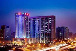 a lit up city at night with buildings at Sheraton Grand Zhengzhou Hotel in Zhengzhou