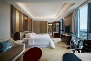 a hotel room with a bed and a couch at Sheraton Grand Zhengzhou Hotel in Zhengzhou