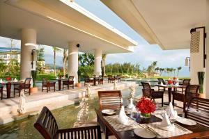 un restaurante con mesas y sillas y una piscina en Sheraton Huizhou Beach Resort, en Huidong