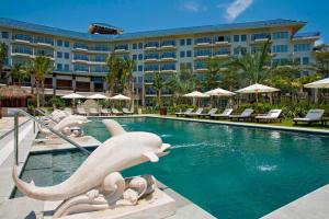 a pool at a resort with statues in the water at Sheraton Huizhou Beach Resort in Huidong