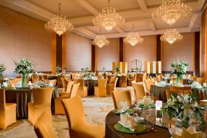 un salón de banquetes con mesas, sillas y lámparas de araña en Sheraton Huizhou Beach Resort, en Huidong