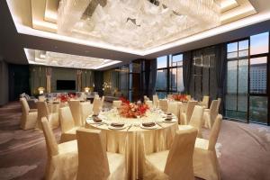 a dining room with a long table and chairs at Sheraton Grand Zhengzhou Hotel in Zhengzhou +32 photos