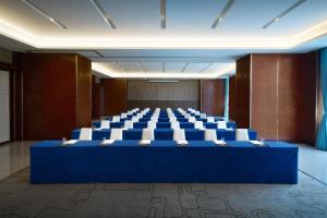 a large conference room with a blue table and chairs at Sheraton Grand Zhengzhou Hotel in Zhengzhou