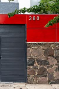 un garaje con una puerta de garaje roja y negra en Casa Corazon, en Guadalajara