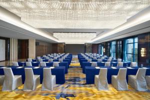 a conference room with blue chairs and a chandelier at Sheraton Grand Zhengzhou Hotel in Zhengzhou