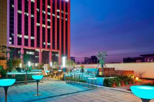 a patio with tables and chairs in front of a building at Sheraton Grand Zhengzhou Hotel in Zhengzhou