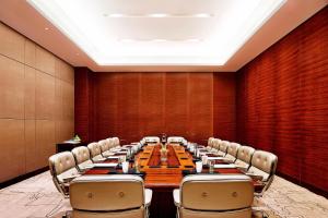 a large conference room with a long table and chairs at Sheraton Grand Zhengzhou Hotel in Zhengzhou