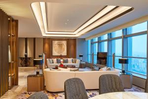 a living room with a couch and tables and windows at The Westin Wenzhou in Wenzhou