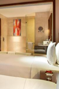 a bedroom with a large white bed and a bathroom at Four Points by Sheraton Taicang in Taicang
