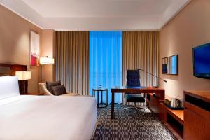 a hotel room with a bed and a desk at Four Points by Sheraton Taicang in Taicang