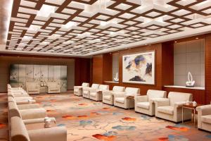 Four Points by Sheraton Taicang في Taicang: غرفة بها كراسي بيضاء وغرفة انتظار مع aasteryasteryasteryasteryastry