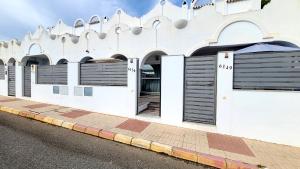 un edificio blanco con persianas negras en una calle en Casa Find Marbella - beautiful holiday home duplex apartment, en Marbella