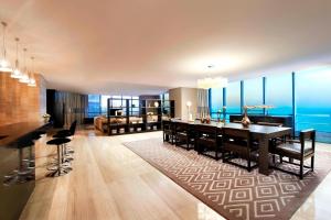 a living room with a dining table and a couch at Four Points by Sheraton Qingdao, West Coast in Huangdao